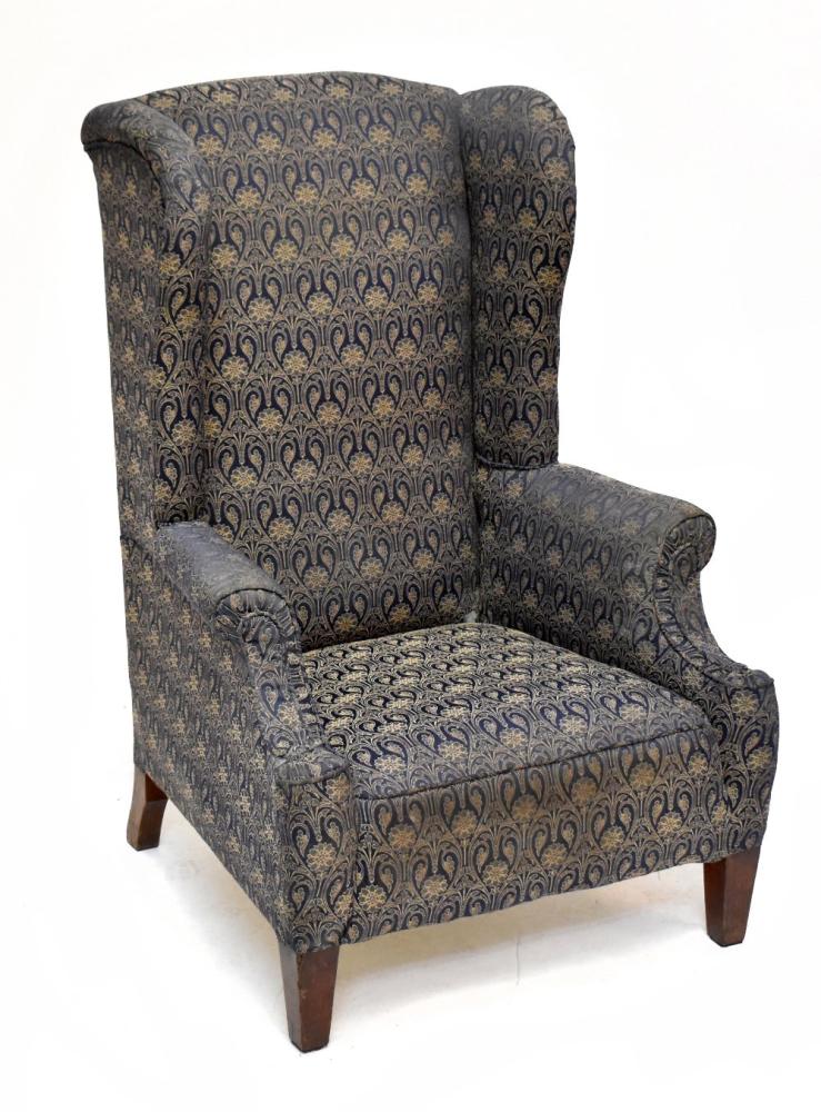 An Edwardian wing back armchair raised on square section tapering front ...