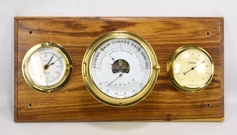 A brass cased ship's style barometer, hygrometer and clock three piece set mounted on wooden