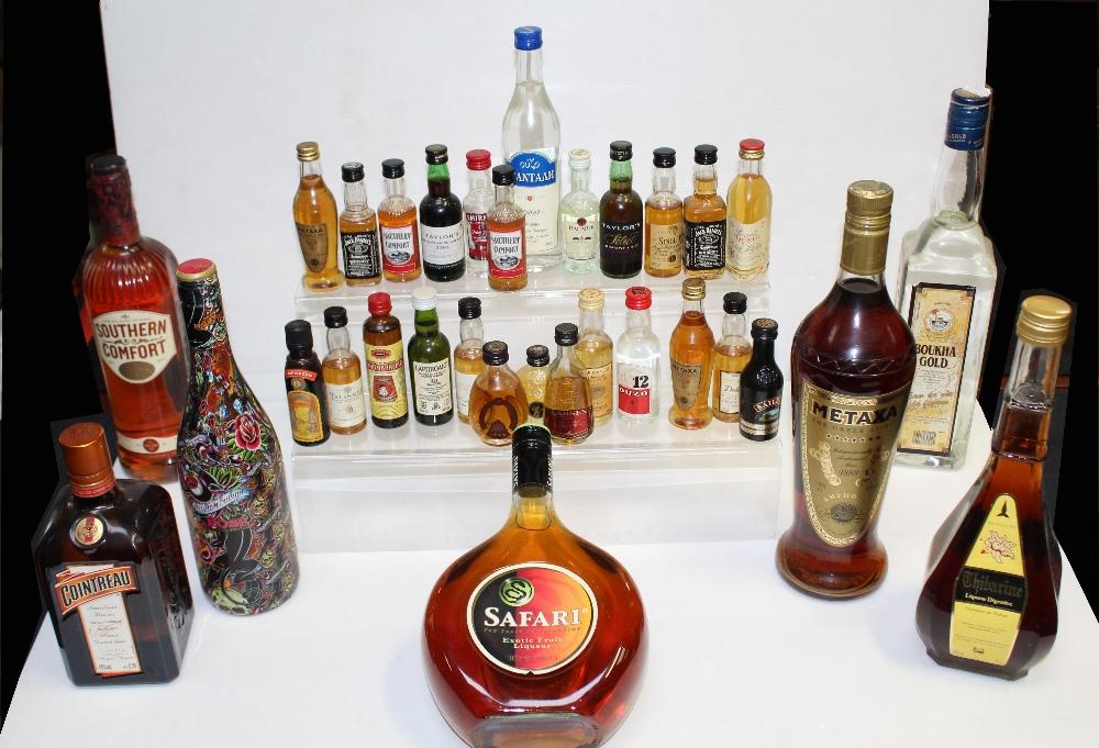 A group of various bottles of alcohol to include Boukha Gold a